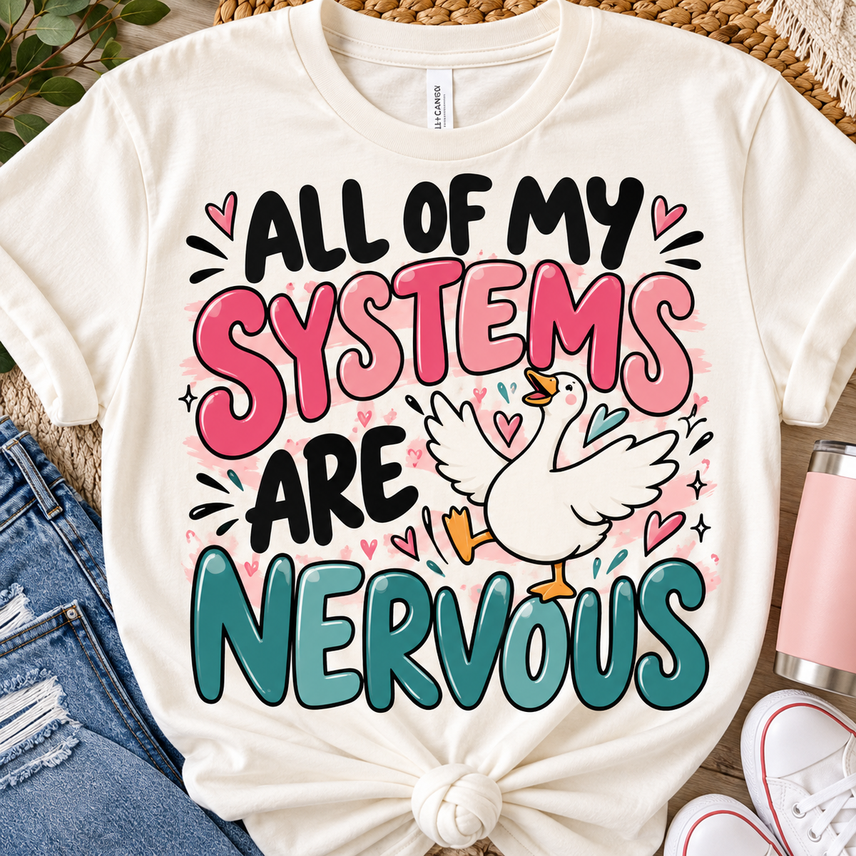 Cream tee with pink, teal, and black All of My Systems Are Nervous goose graphic